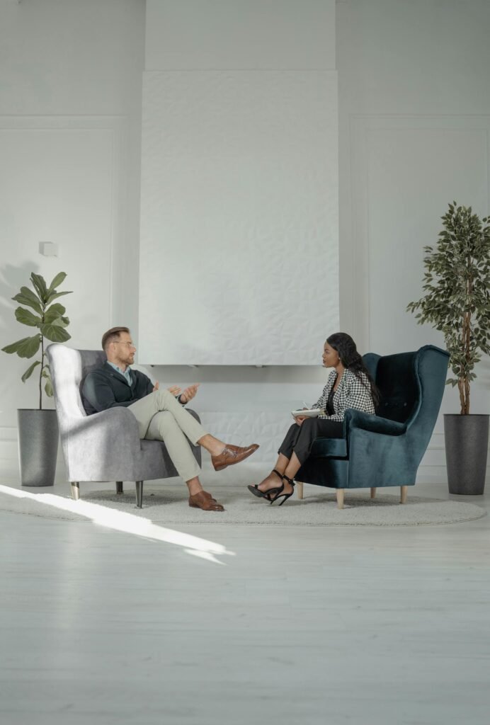 CEO interviewed by a tv host at office, sitting in sofas.