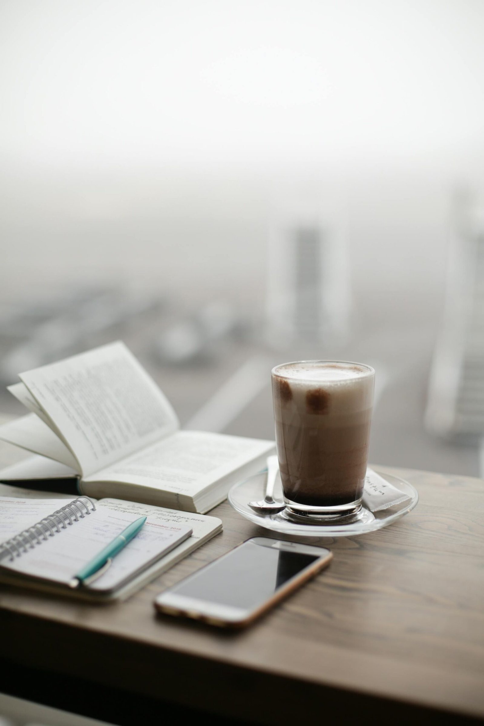 Cup of coffee and morning diary placed in the window by a student, near paris